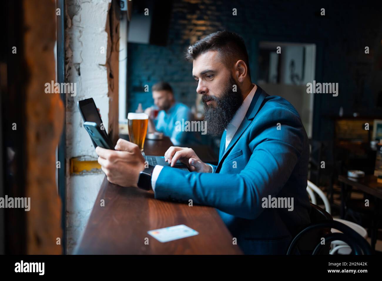 Young businessman using his smartphone in a bar Stock Photo