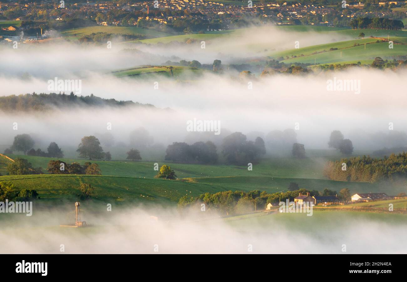 A telephoto shot of the Craven District landscape captured from Sharp Haw compresses the misty view into layers on an early autumn morning. Stock Photo