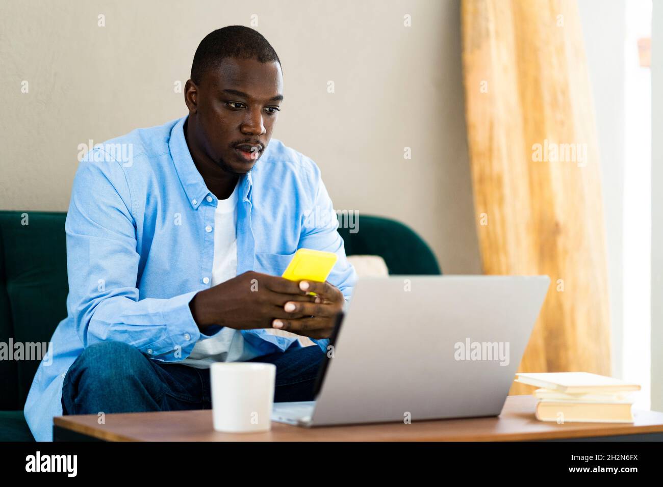 Male freelance worker using smart phone while working at home Stock Photo