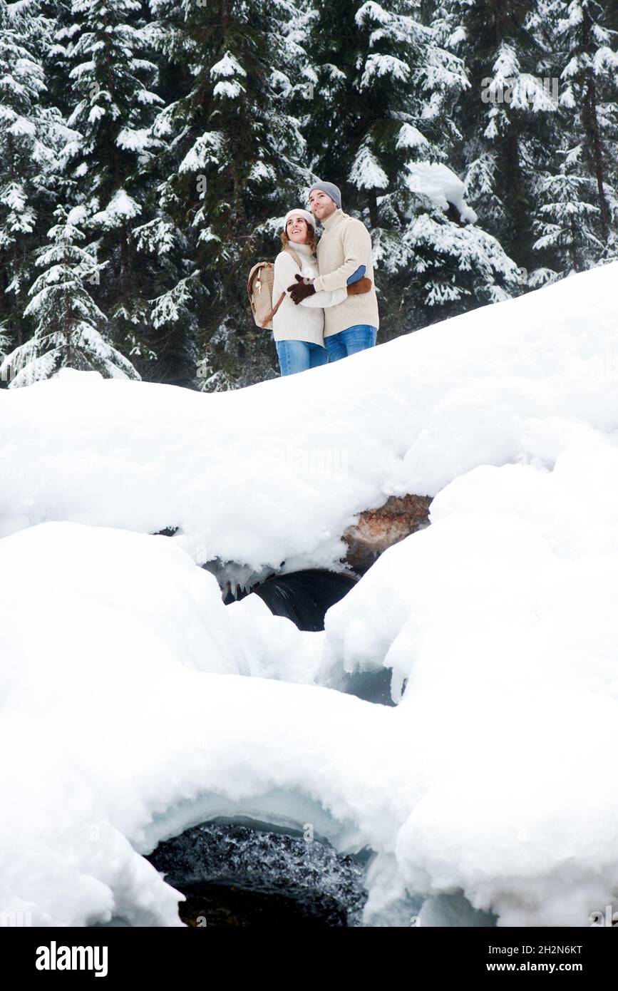 Young couple holding hands while walking on snow Stock Photo
