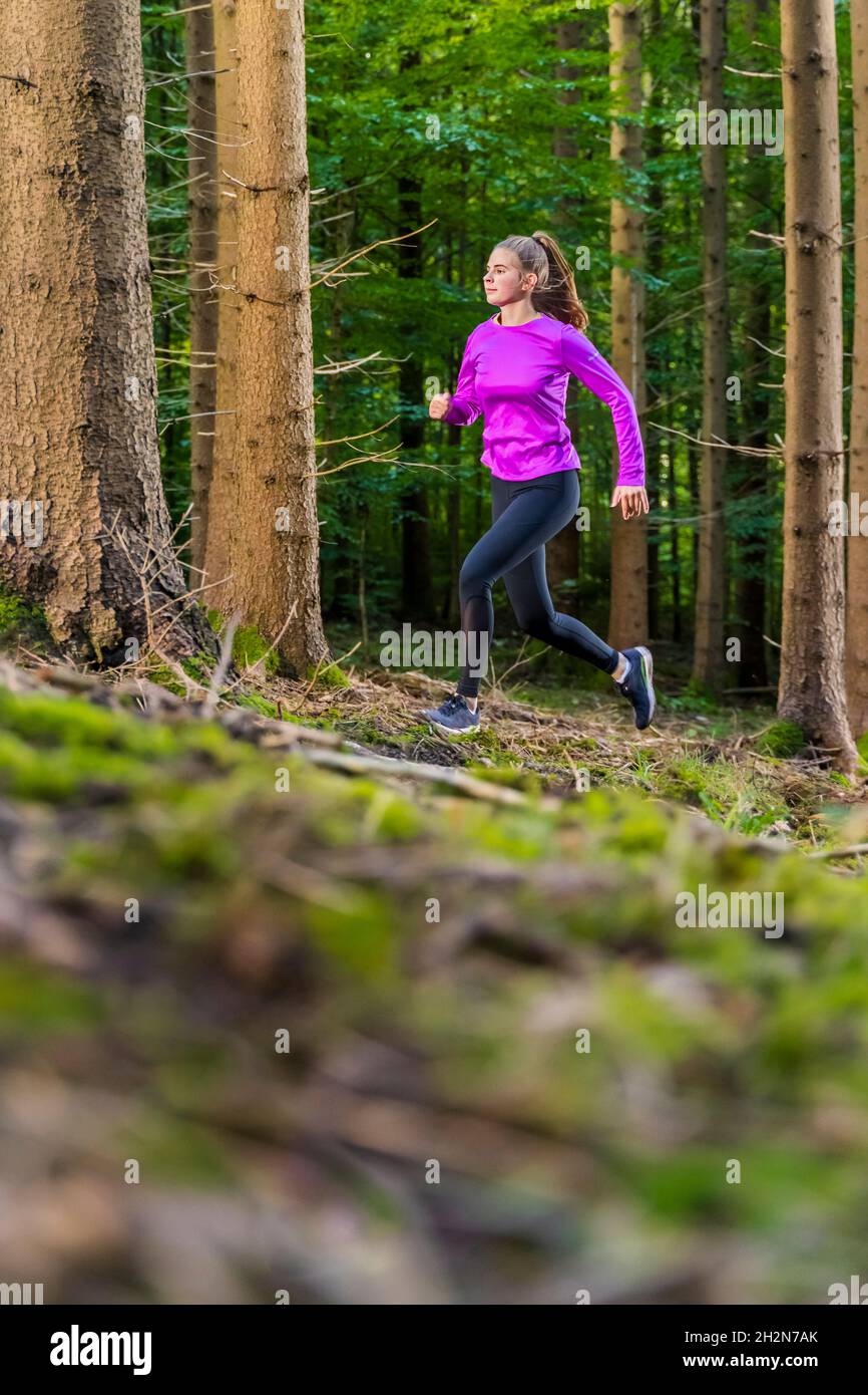 Female athlete running in forest Stock Photo - Alamy