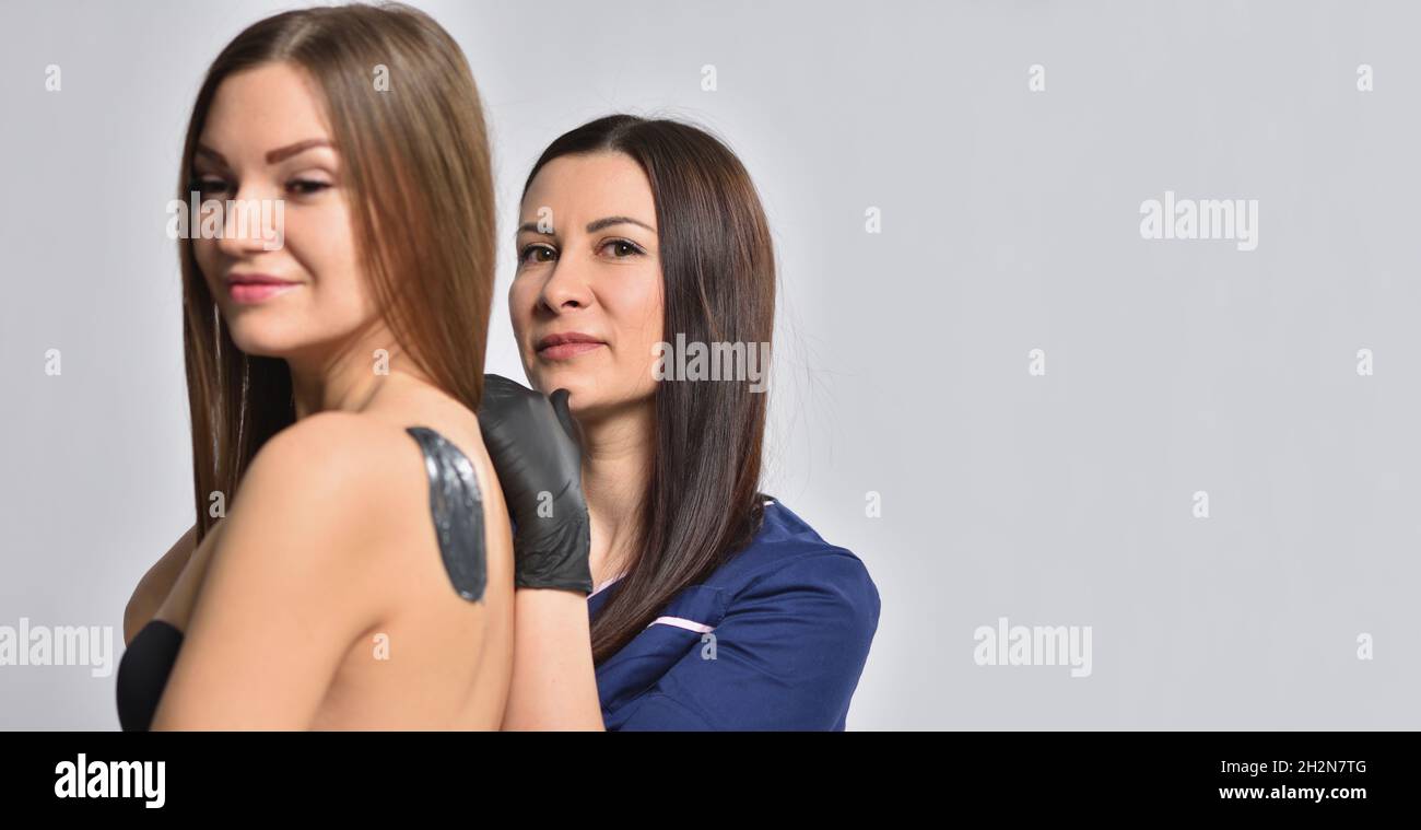 Beautician and client posing during the depilation process. Stock Photo