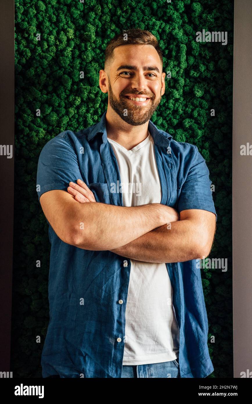 Smiling handsome man standing with arms crossed Stock Photo