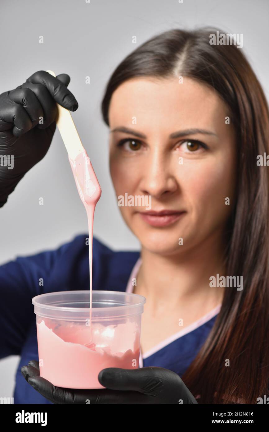 Beautician showing hot wax for waxing depilation, body care and beauty
