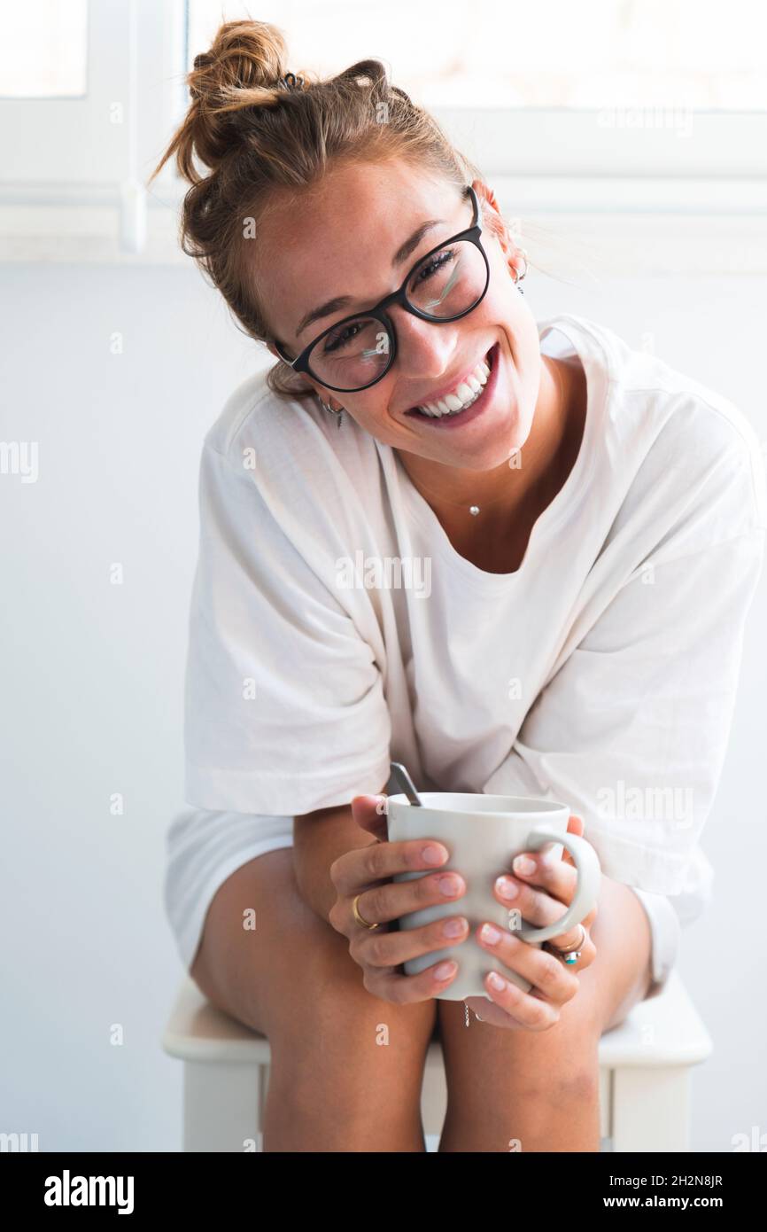 Woman smiling while sitting on stool Stock Photo