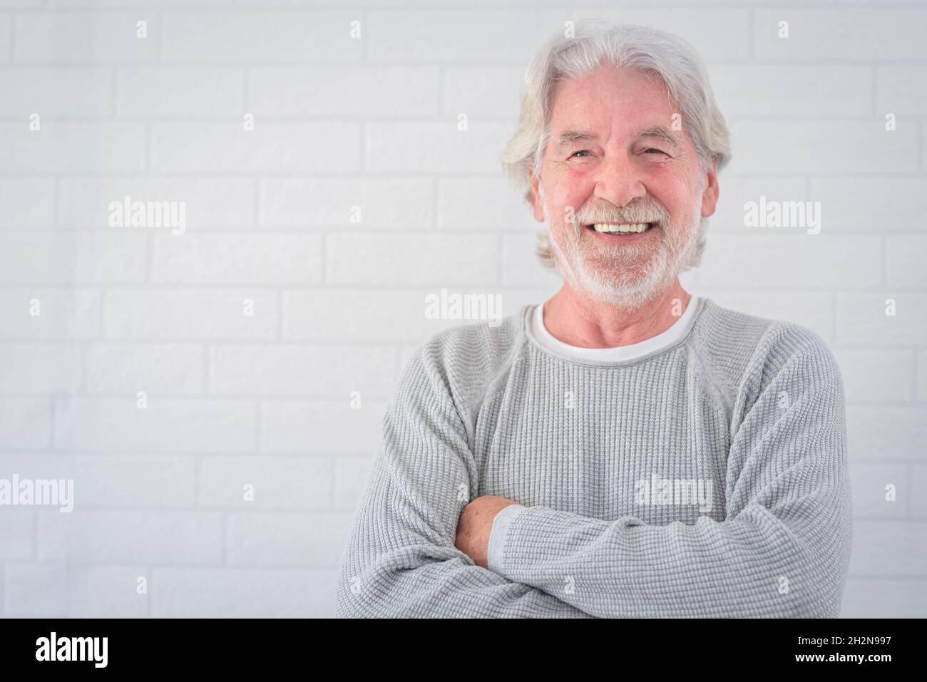 Smiling senior man with arms crossed Stock Photo