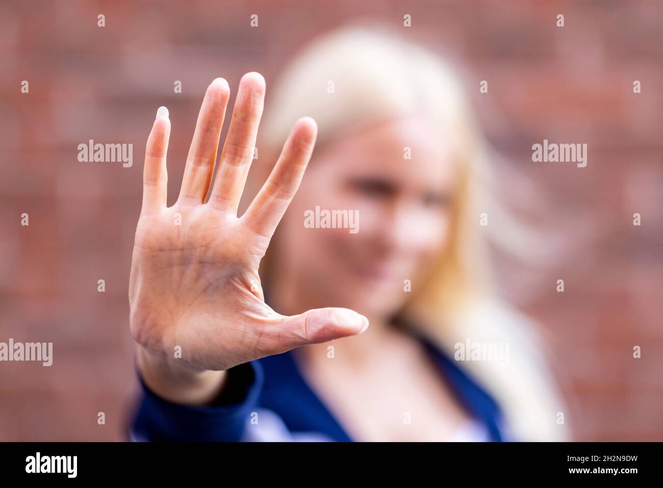 Woman showing stop sign with palm of hand Stock Photo