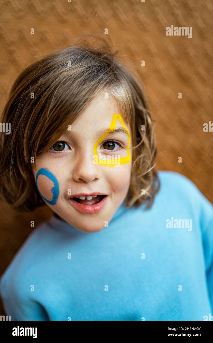 Cute girl with yellow and blue paint on face Stock Photo Alamy