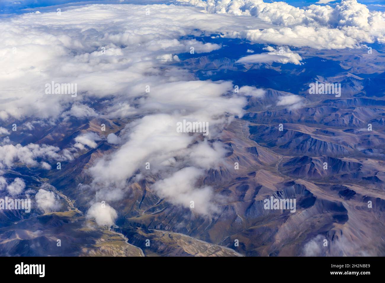 Aerial view above the clouds and mountain peaks on a sunny day Stock ...