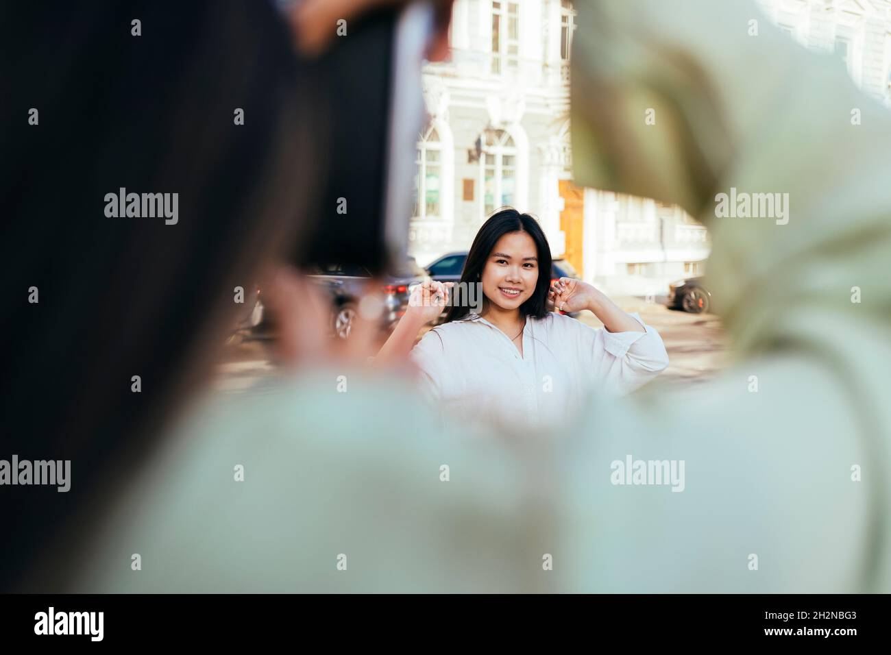 Young woman photographing female friend through camera Stock Photo