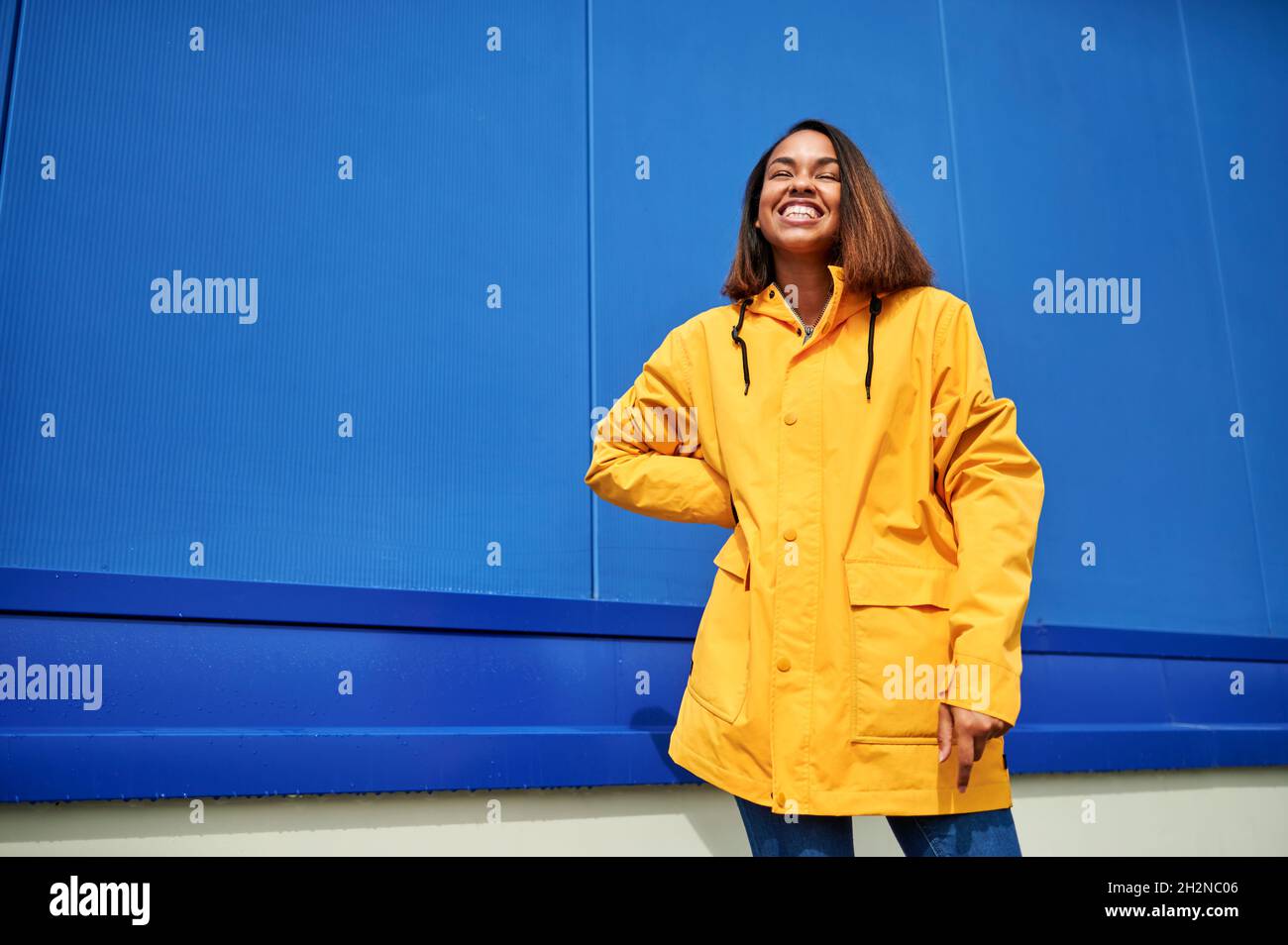 Woman wearing yellow raincoat hi-res stock photography and images - Alamy