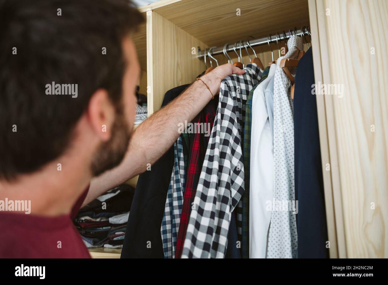Man removing clothes from closet at home Stock Photo