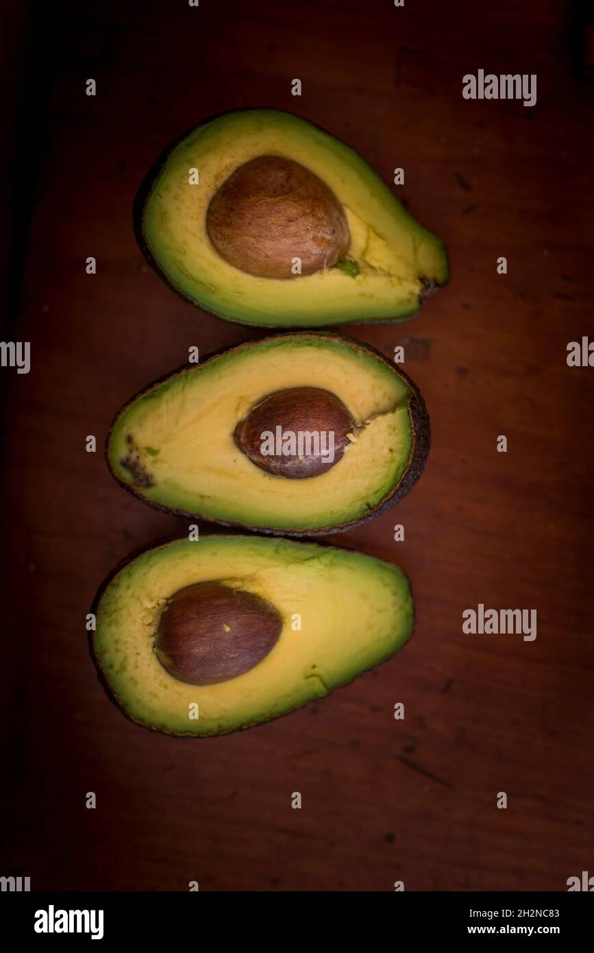 Sliced avocados on wooden table Stock Photo