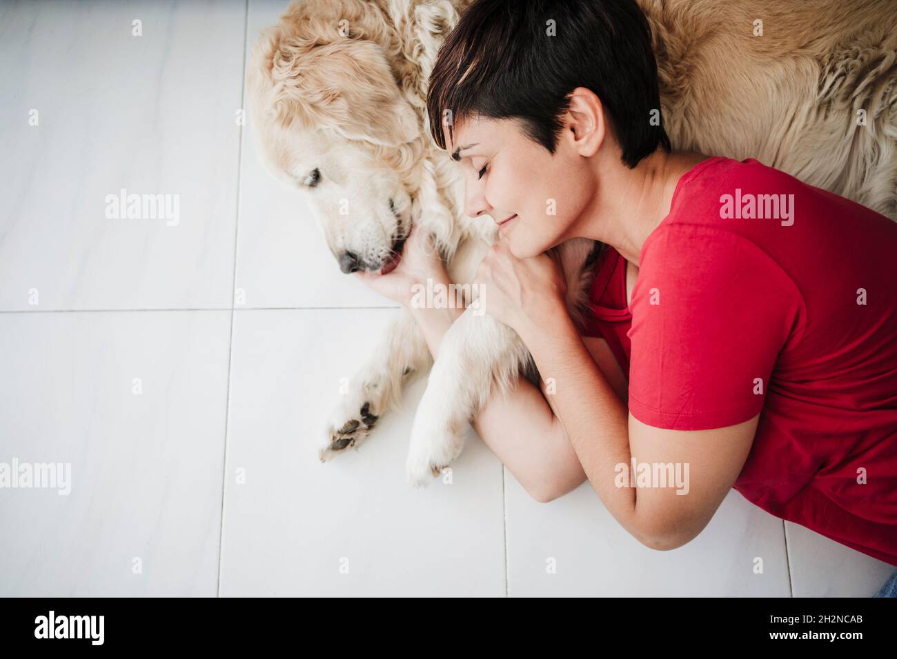 Woman relaxing with Golden retriever at home Stock Photo - Alamy