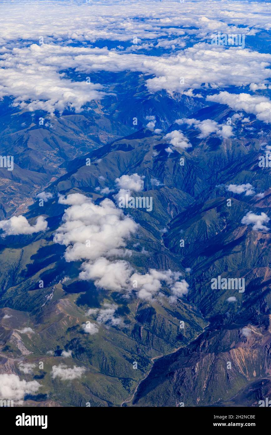 Aerial view above the clouds and mountain peaks on a sunny day Stock ...