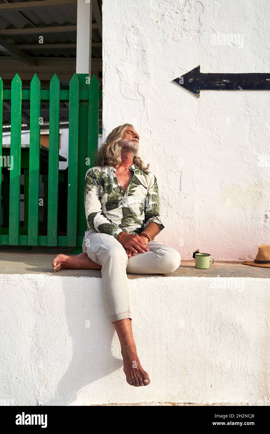 Mature hipster man leaning on wall Stock Photo