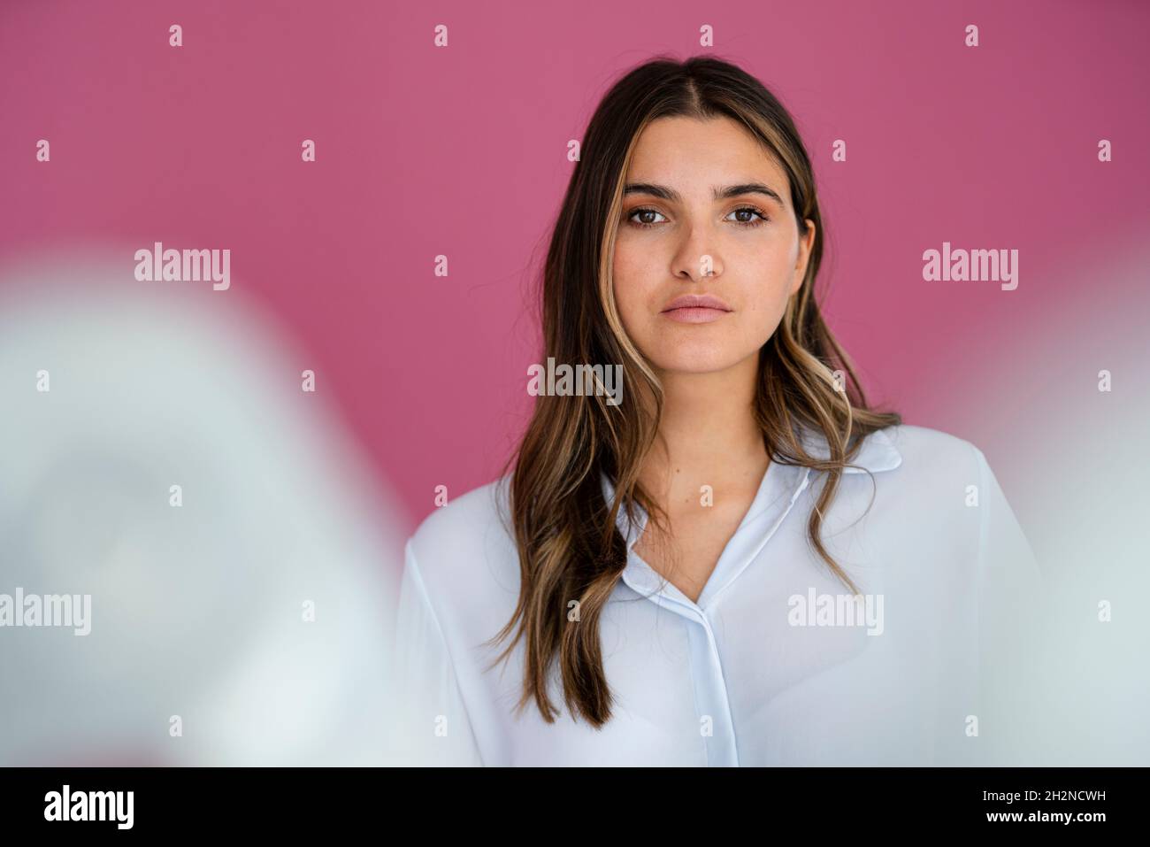 Young female professional in front of pink wall Stock Photo - Alamy