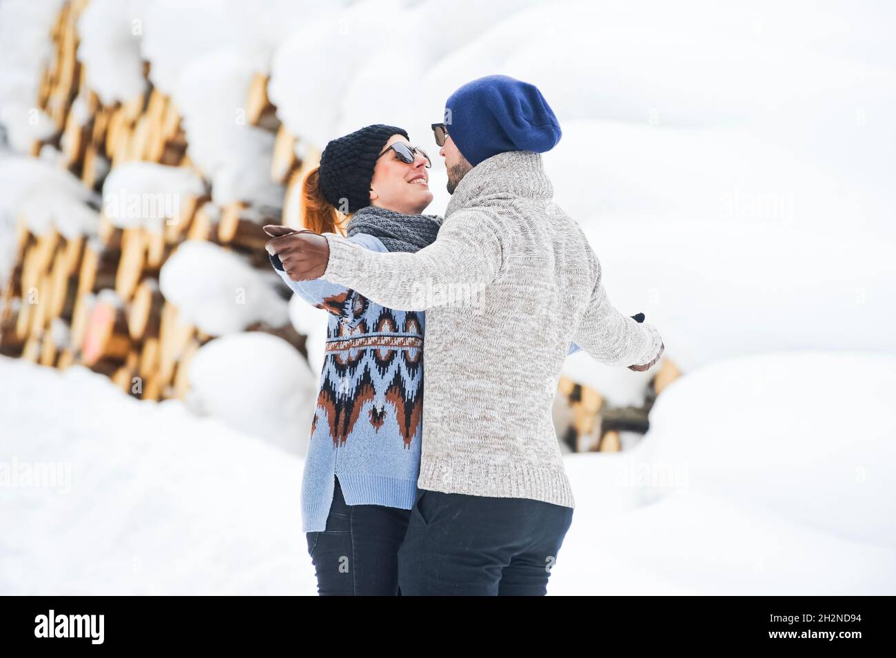 Playful couple kicking snow during winter Stock Photo