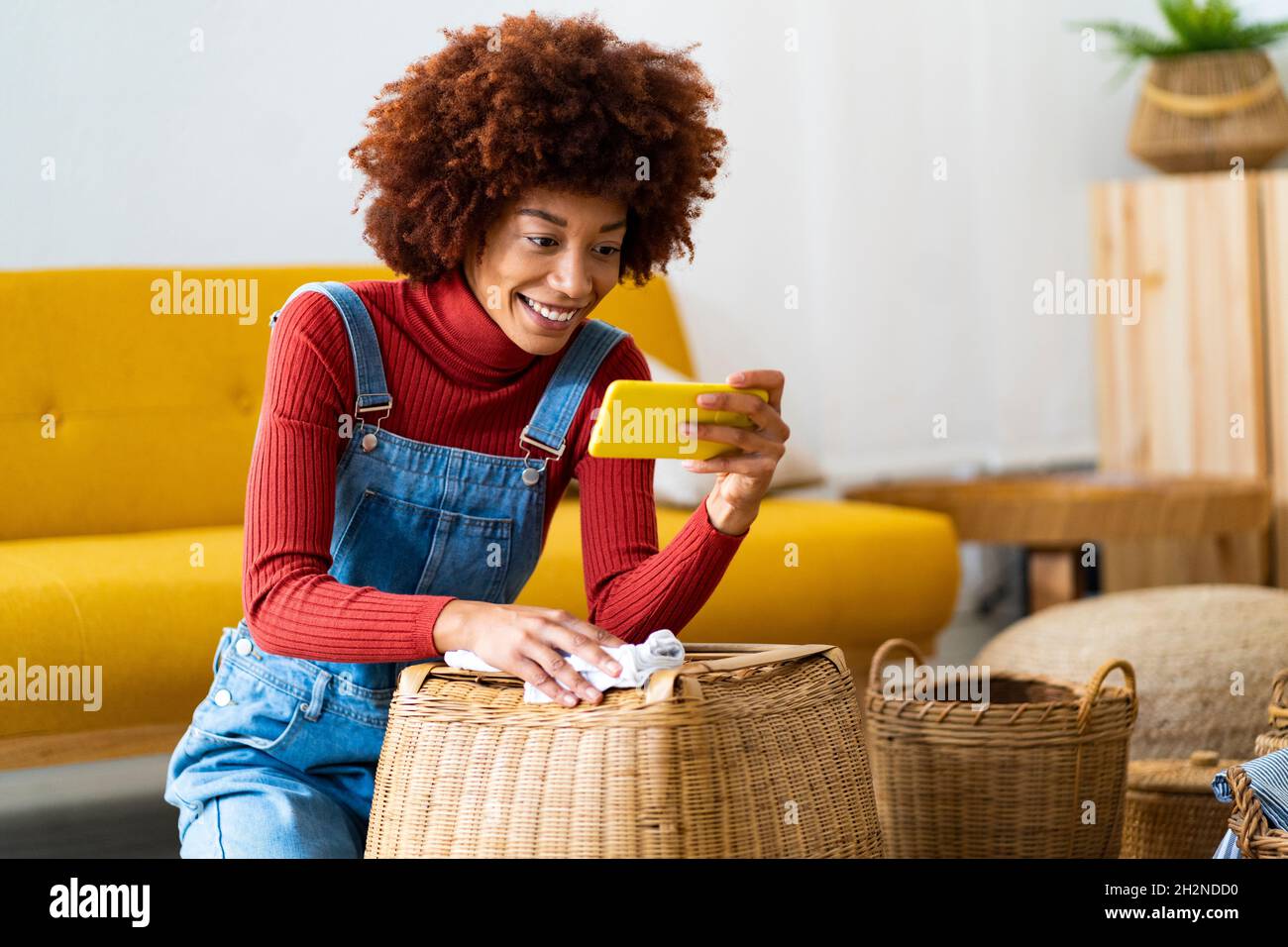 Redhead woman cleaning wicker basket in living room Stock Photo Alamy