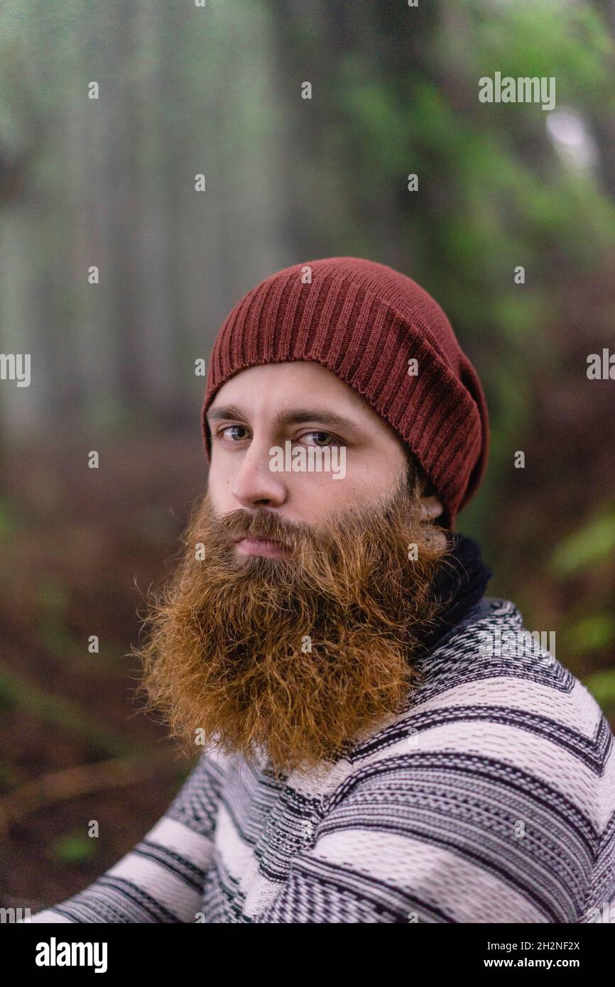 Bearded young man with knit hat at woodland Stock Photo