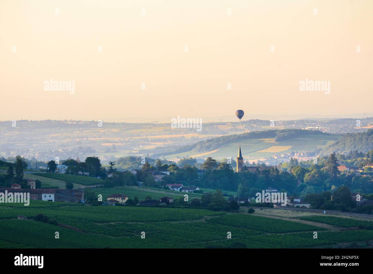 Baloon flying over Le Bois d'Oingt village, Beaujolais Stock Photo