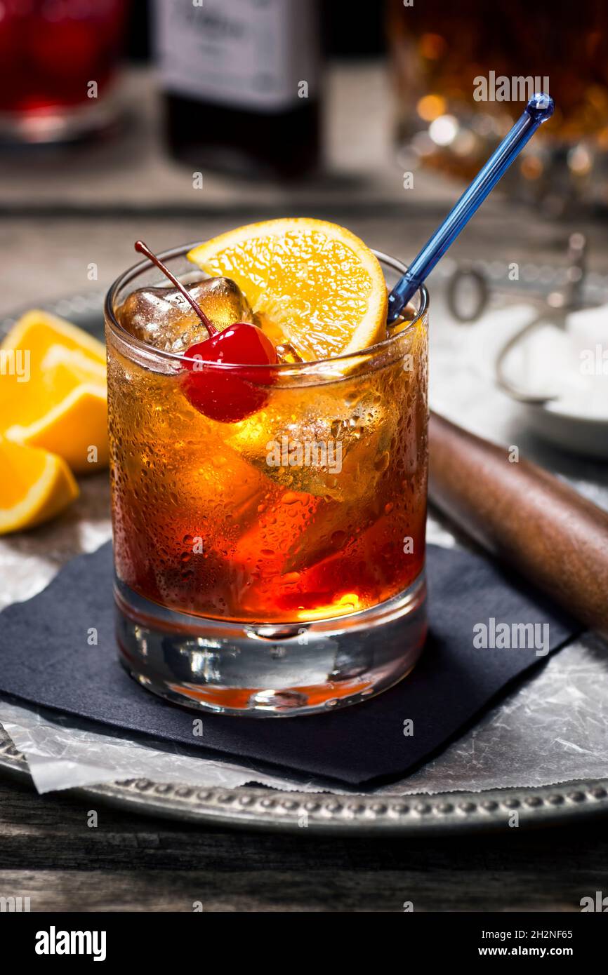 Old Fashioned Cocktail in Rocks Glass with Ingredients and Bar Tools in Dark Vintage Wooden Bar Stock Photo