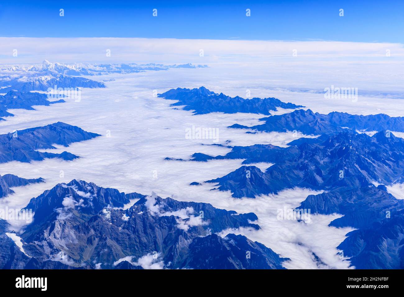 Aerial view above the clouds and mountain peaks on a sunny day Stock ...