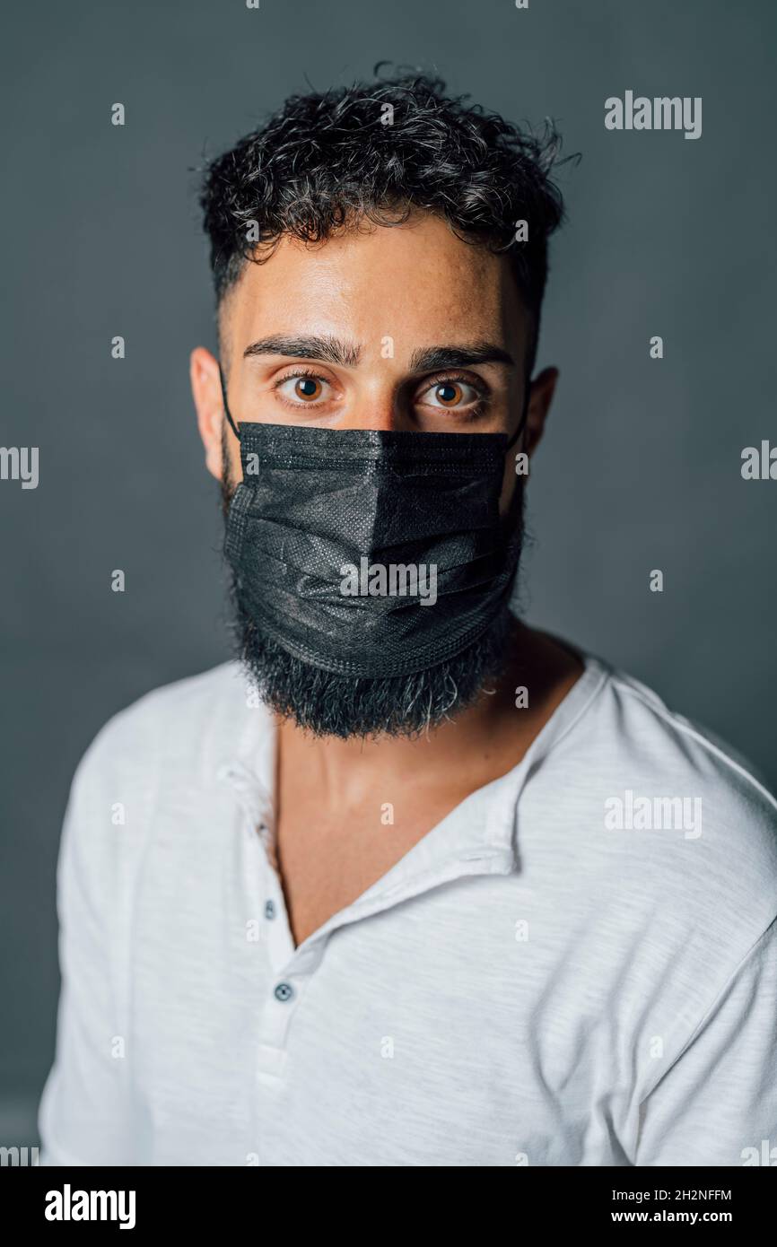 Young man wearing protective face mask in studio Stock Photo