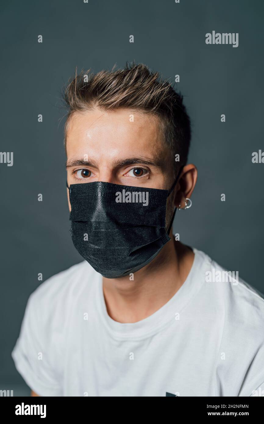 Young man wearing protective face mask in studio Stock Photo