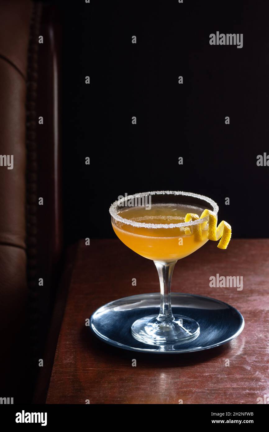 Sidecar Cocktail with Sugared Rim in Coupe Glass in a Dark Luxurious Bar with Copy Space Stock