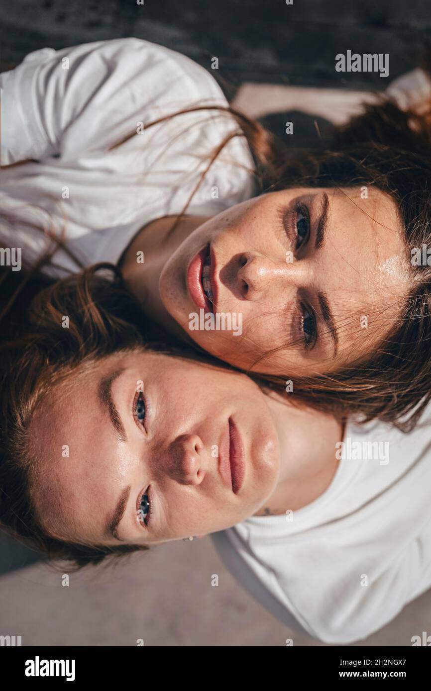 Young women touching faces during sunny day Stock Photo