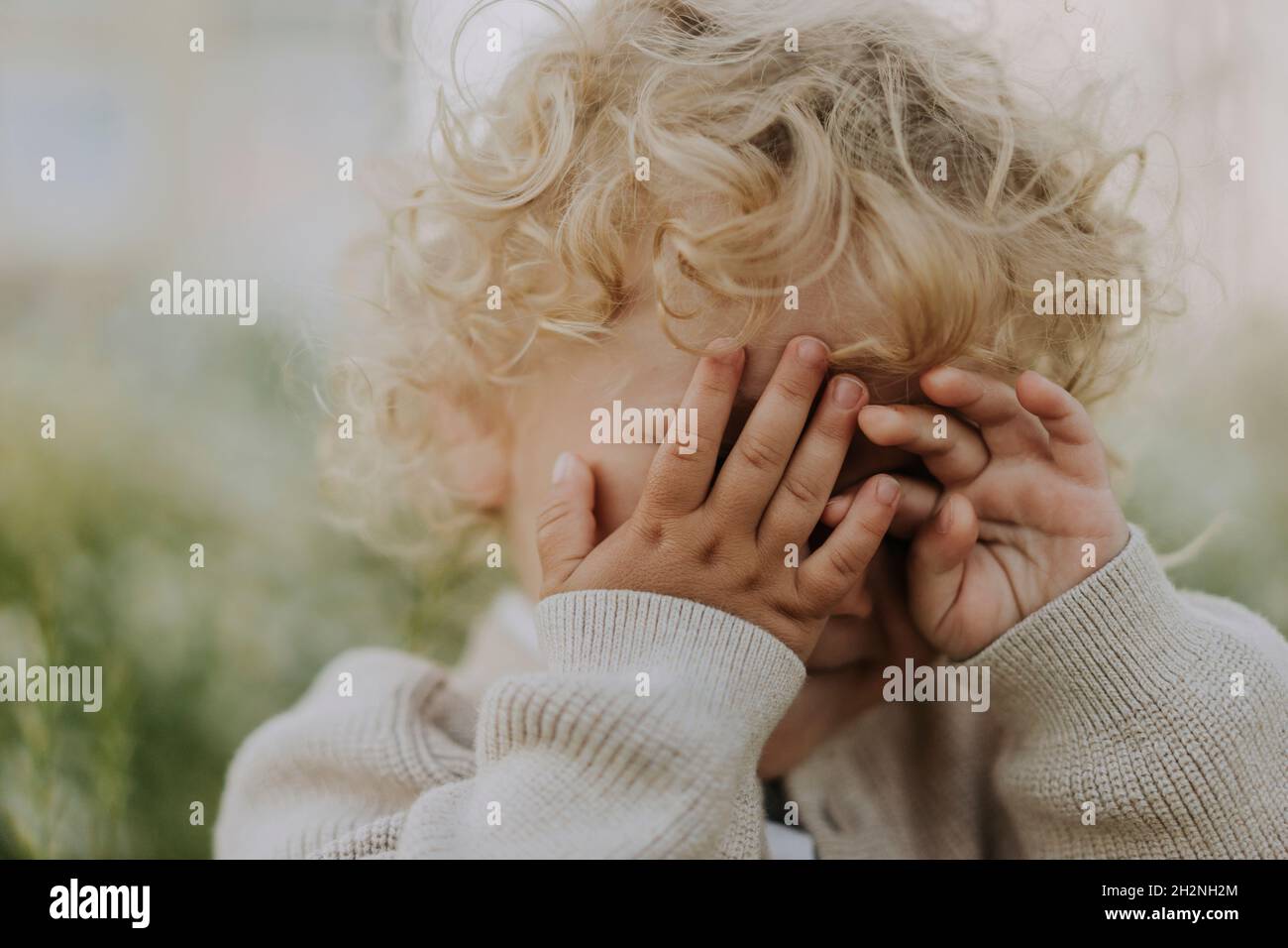 Cute baby boy covering eyes with hands Stock Photo - Alamy