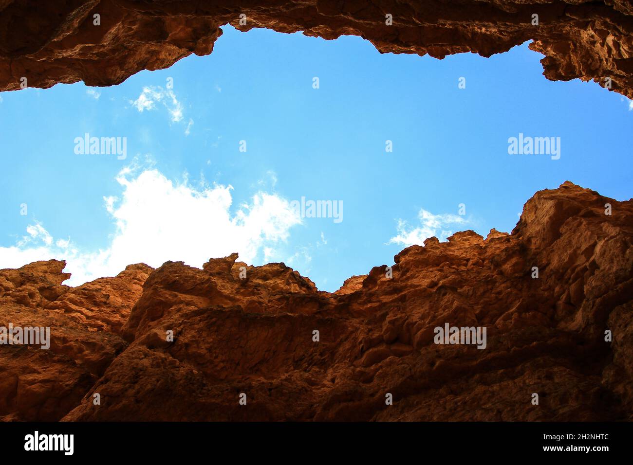 Canyon floor view, Clear bright blue sky between two rock walls Two cliffs facing each other with sky with white cloud between them beautiful view Stock Photo