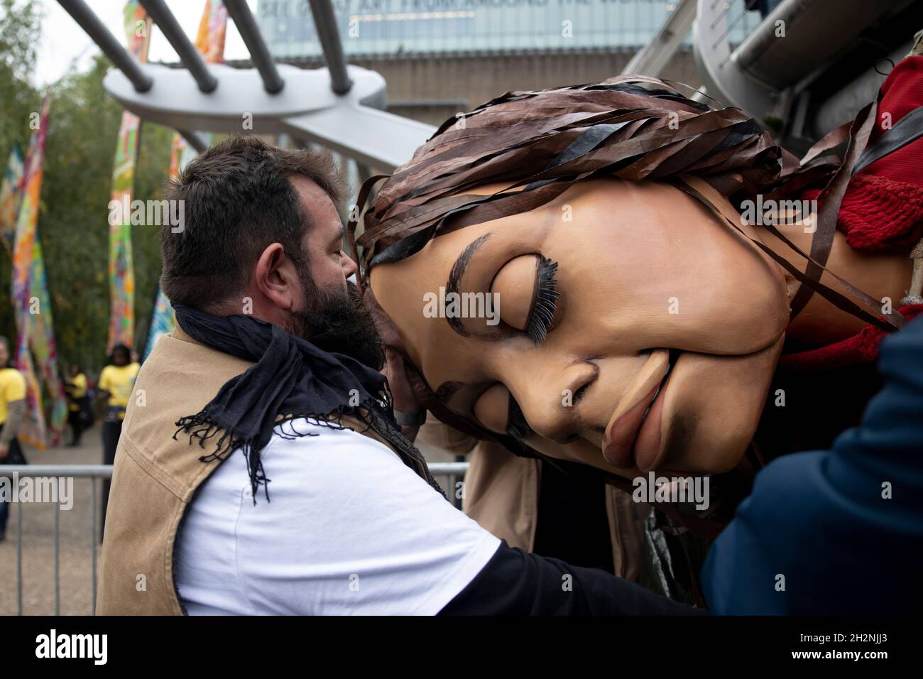 London, UK. 23rd Oct, 2021. Staff member helps to transport the giant puppet (Little Amal) passing under the bridge.Little Amal, a 3.5 meters tall puppet portrayed as a 9 year old Syrian refugee girl and representing all refugee children, arrived central London at the Great Door of the St Paul Cathedral. She has been on journey since July this year departing from the Syrian-Turkish border in search of her 'mother'. She will walk 8000 km and arrive at Manchester in early November as her final destination, where it is also the location of the short term holding facility for refugees in the UK. C Stock Photo