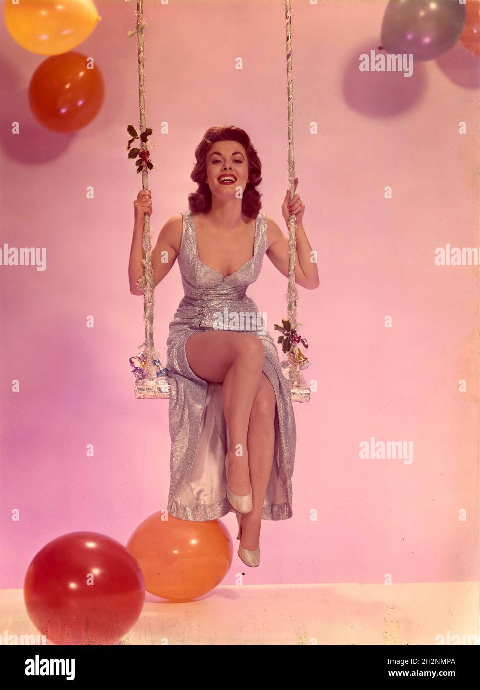 ANNE HEYWOOD circa 1958 colour leggy pin up portrait Christmas and New Year publicity for J. Arthur Rank Organisation Stock Photo