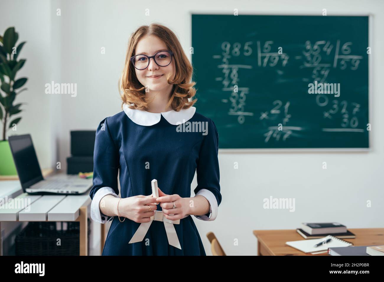 Portrait of smiling school girl with chalk in her hands Stock Photo