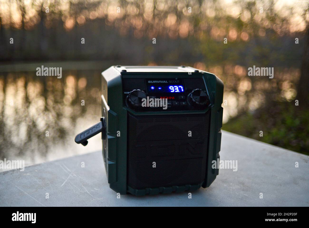 Ion Survival Scout portable hand crank solar powered emergency weather radio on table at campsite in the woods during sunset, Woodford, Wisconsin, USA Stock Photo