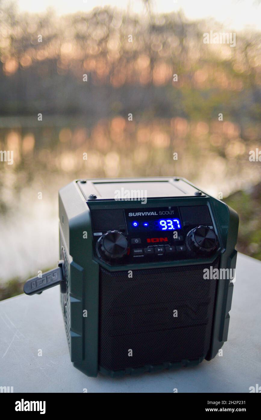 Ion Survival Scout portable hand crank solar powered emergency weather radio on table at campsite in the woods during sunset, Woodford, Wisconsin, USA Stock Photo
