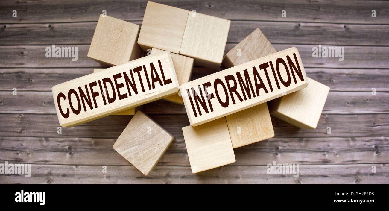 the text of the Confidential Information is written on the web blocks and on a brown background. Top secret Stock Photo