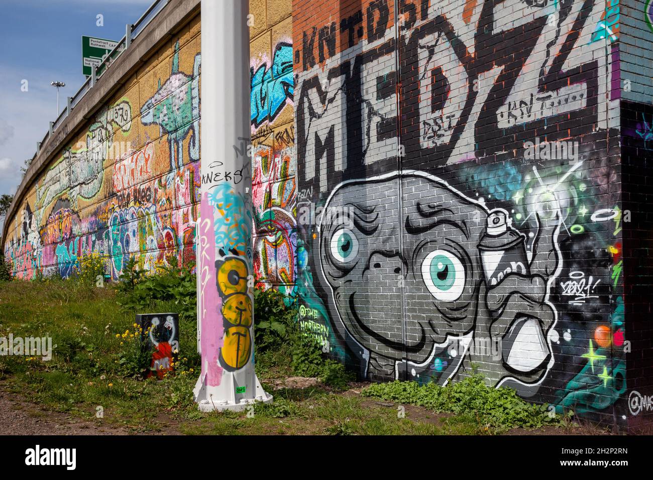 Colourful graffiti / street art next to the River Aire riverside path in Leeds, West Yorkshire Stock Photo