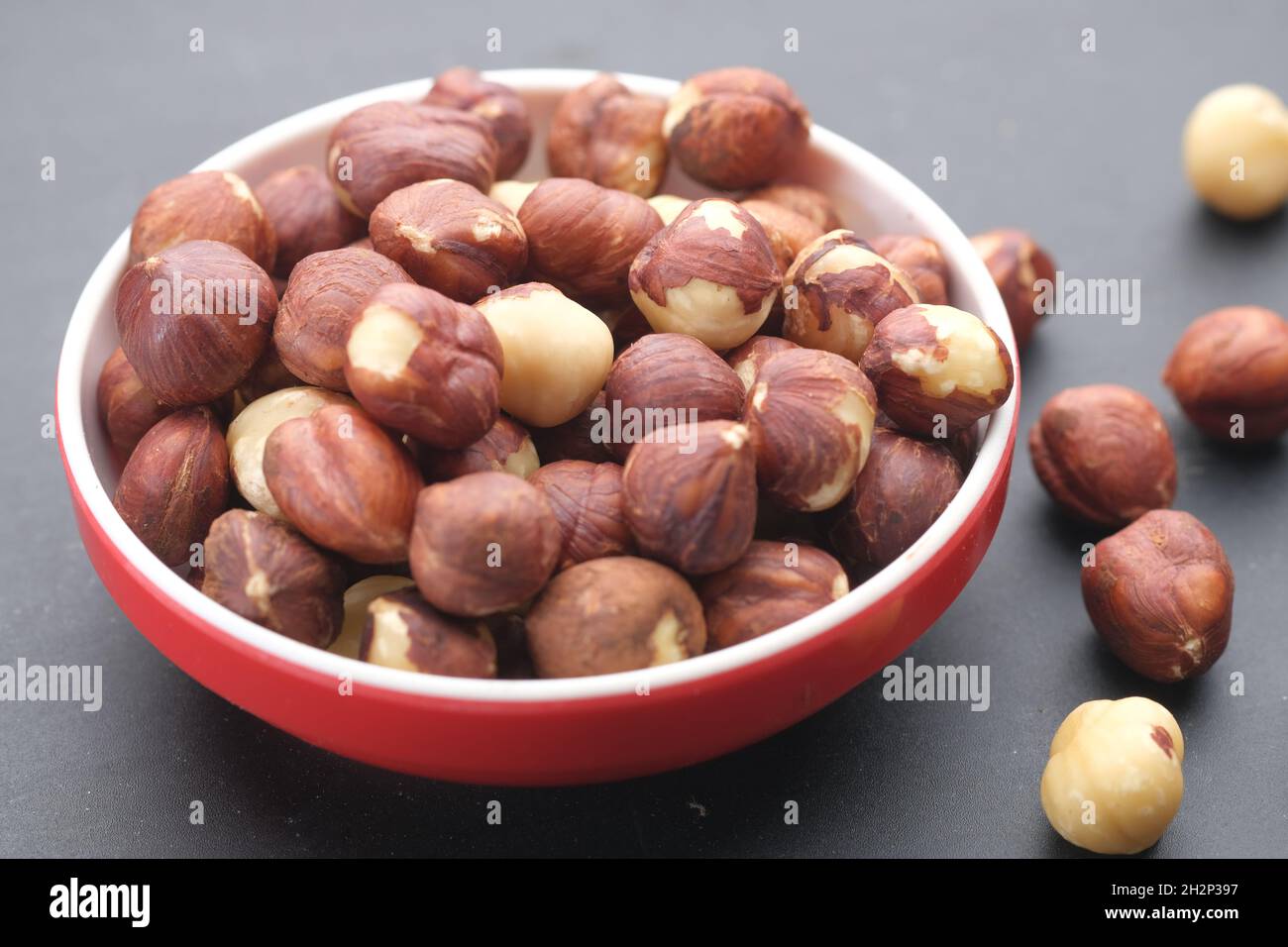hazelnuts in a container on black background, Stock Photo