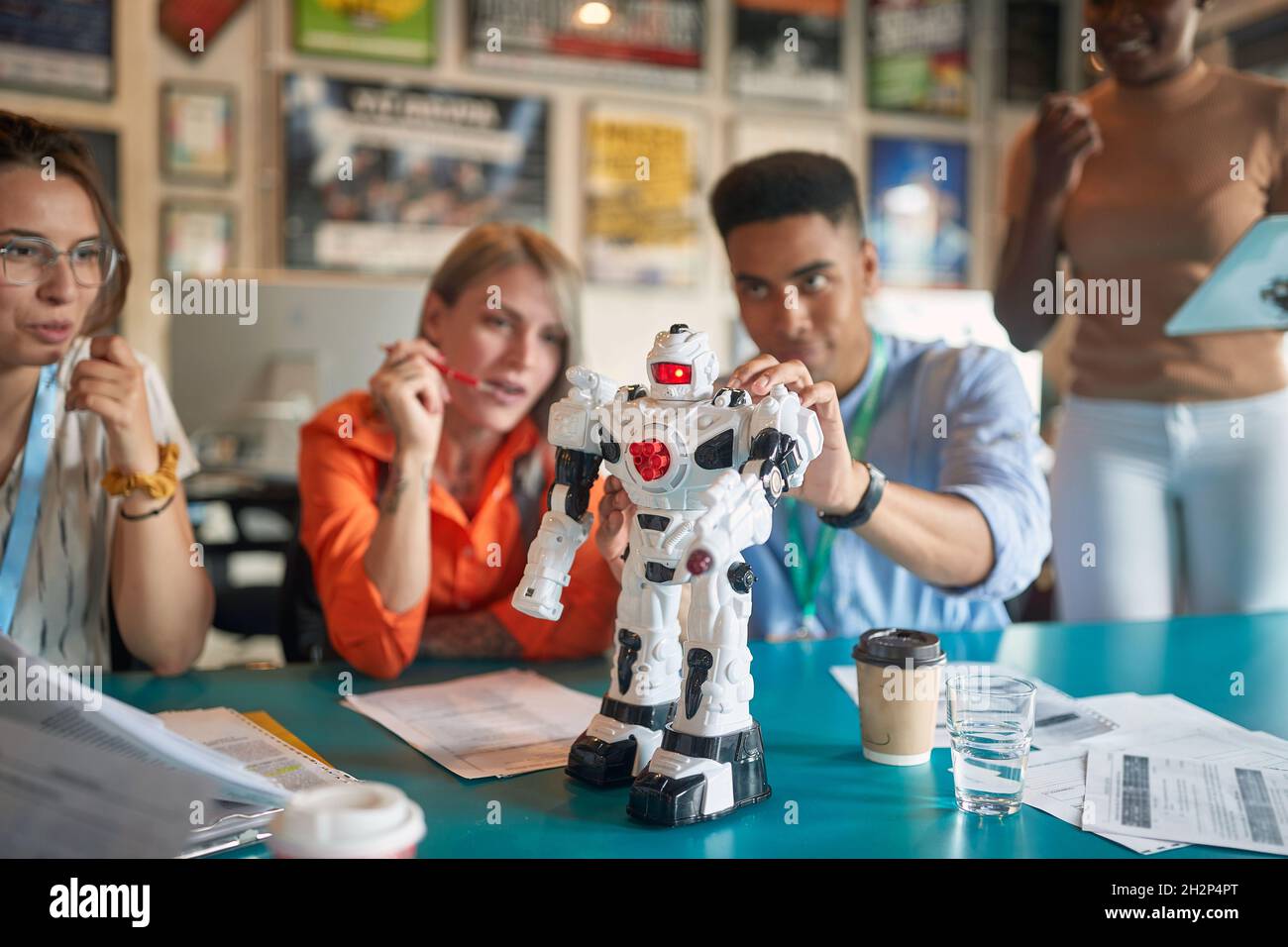 Group of young engineers collaborating together on a robot Stock Photo ...