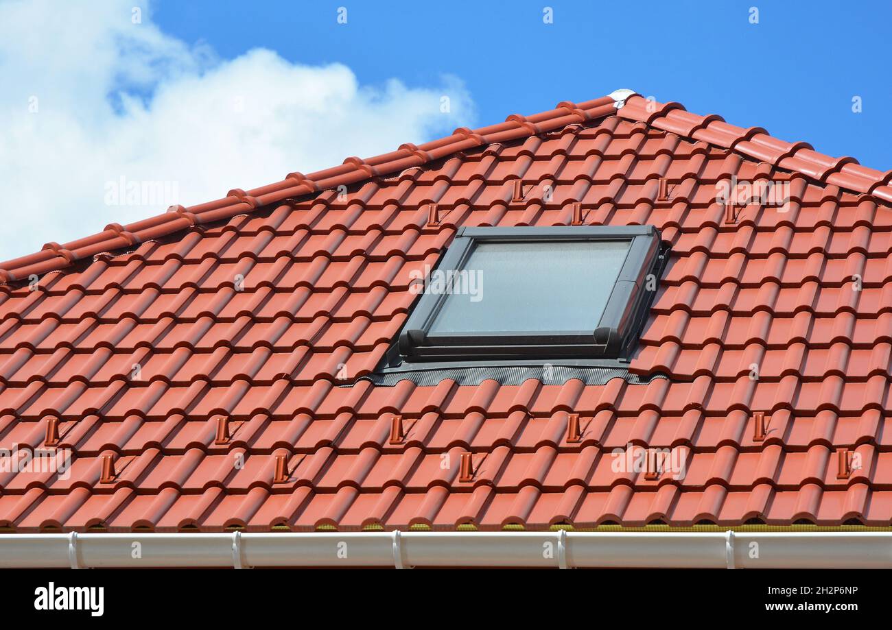 Skylight on red ceramic roof tiles house roof. Modern Roof Skylight. Attic Skylights Home Design