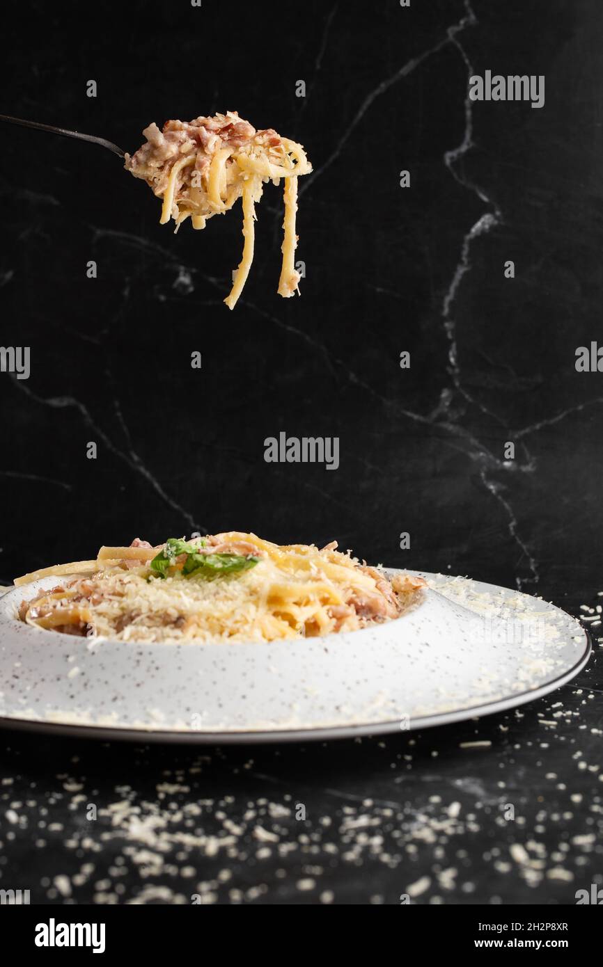 Pasta Carbonara On Fork Isolated Spaghetti With Bacon Parmesan Cream Sauce And Egg Yolk On Black Marble Background Mediterranean Gourmet Food Stock Photo Alamy
