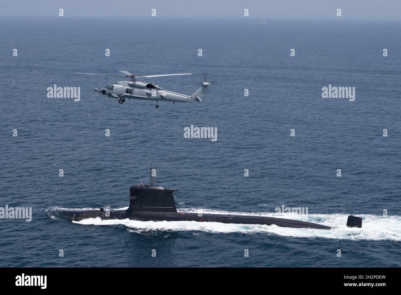 San Diego, United States. 16 August, 2021. A U.S. Navy MH-60R Seahawk helicopter flies over a Chilean Navy Scorpene Class Submarine CS Carrera during Diesel-Electric Submarine multi-national Initiative Hoist Exercise 2021 August 16, 2021 near San Diego, California.  Credit: MC2 Sara Eshleman/U.S. Navy/Alamy Live News Stock Photo