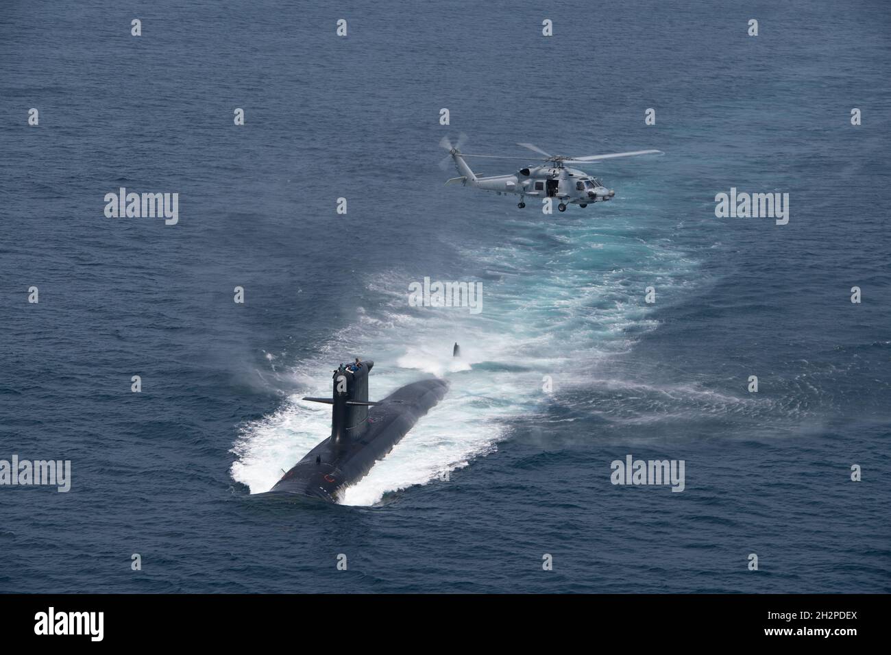 San Diego, United States. 16 August, 2021. A U.S. Navy MH-60R Seahawk helicopter flies over a Chilean Navy Scorpene Class Submarine CS Carrera during Diesel-Electric Submarine multi-national Initiative Hoist Exercise 2021 August 16, 2021 near San Diego, California.  Credit: MC2 Sara Eshleman/U.S. Navy/Alamy Live News Stock Photo