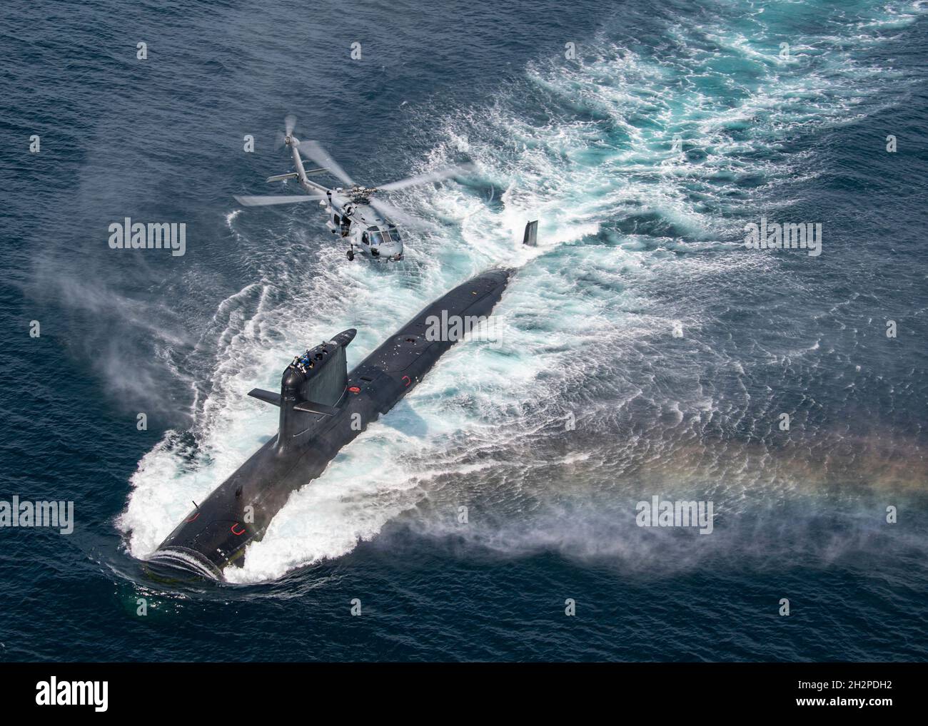 San Diego, United States. 16 August, 2021. A U.S. Navy MH-60R Seahawk helicopter flies over a Chilean Navy Scorpene Class Submarine CS Carrera during Diesel-Electric Submarine multi-national Initiative Hoist Exercise 2021 August 16, 2021 near San Diego, California.  Credit: MC2 Chelsea Meiller/U.S. Navy/Alamy Live News Stock Photo