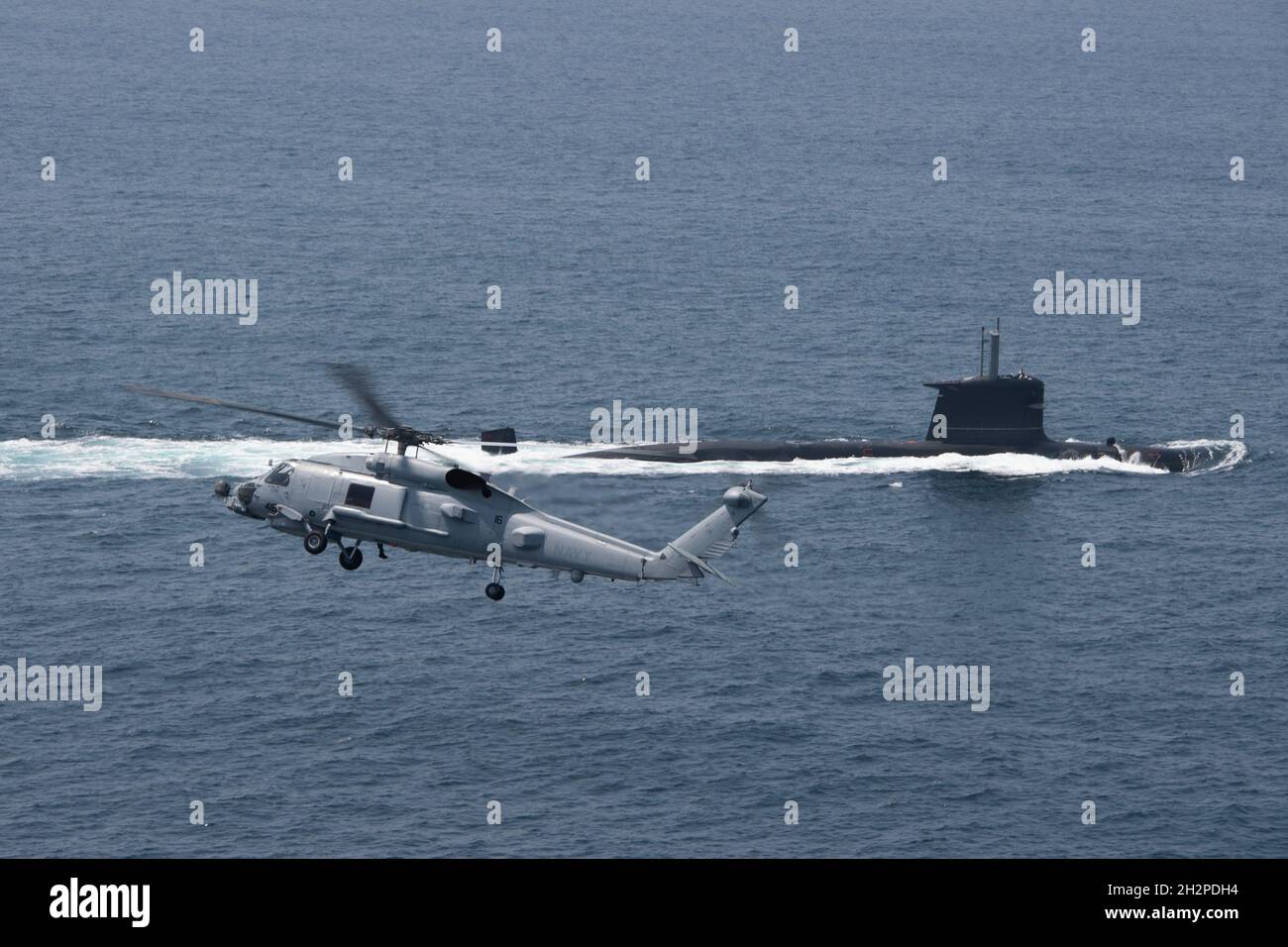 San Diego, United States. 16 August, 2021. A U.S. Navy MH-60R Seahawk helicopter flies over a Chilean Navy Scorpene Class Submarine CS Carrera during Diesel-Electric Submarine multi-national Initiative Hoist Exercise 2021 August 16, 2021 near San Diego, California.  Credit: MC2 Sara Eshleman/U.S. Navy/Alamy Live News Stock Photo