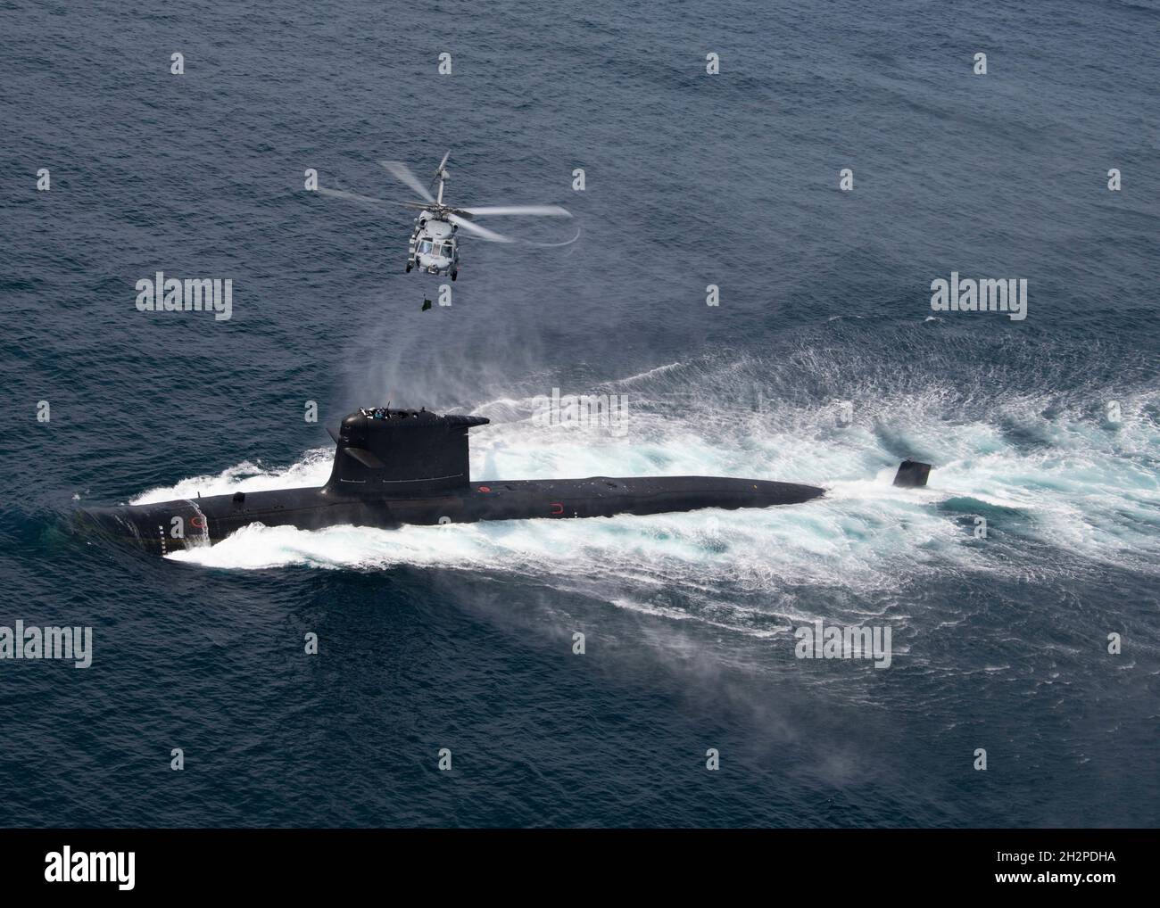 San Diego, United States. 16 August, 2021. A U.S. Navy MH-60R Seahawk helicopter lowers a bag by hoist to the Chilean Navy Scorpene Class Submarine CS Carrera during Diesel-Electric Submarine multi-national Initiative Hoist Exercise 2021 August 16, 2021 near San Diego, California.  Credit: MC2 Chelsea Meiller/U.S. Navy/Alamy Live News Stock Photo