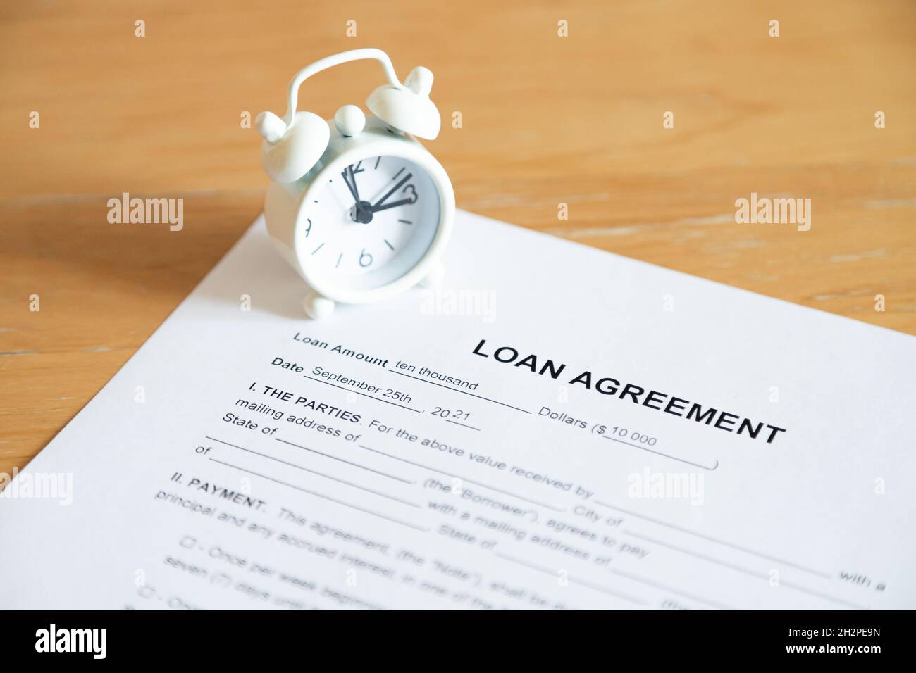 Time to pay debt - expired loan agreement and little wintage clock Stock Photo